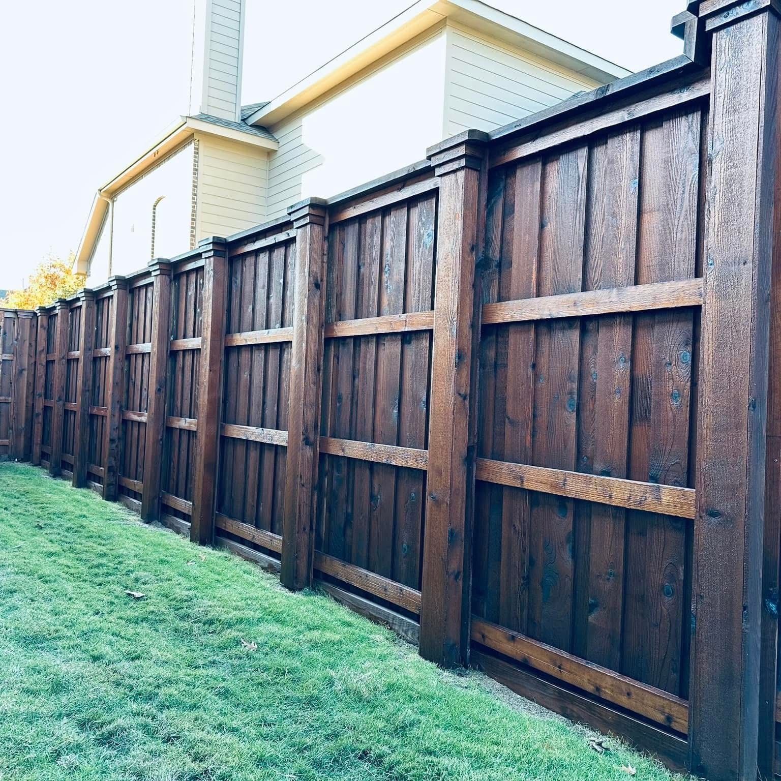 Stained cedar privacy fence with a top cap and trim